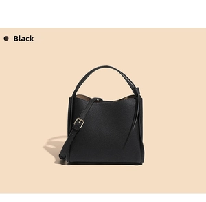 Detail of black lychee grain leather bucket bag with gold hardware and strap