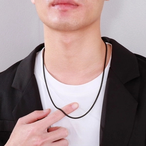 Close-up of minimalist black metal chain necklace worn by a male model on a white tee