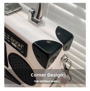 Detail of white radio-shaped crossbody bag featuring metal handle and reinforced corners