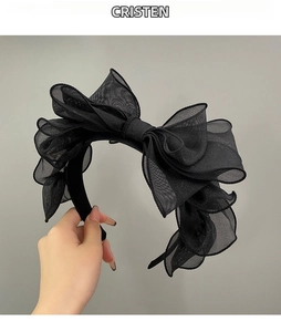 Detail of multi-layered black mesh gauze bow headband with textured puffy fabric design