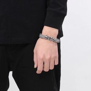 Detail of silver twisted rope knot bracelet on wrist with rugged industrial style