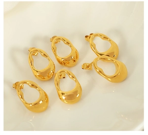 Detailed macro view of three pairs of irregular geometric hollow gold stud earrings