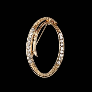 Elegant gold oval brooch with clear rhinestones in a swirling double loop design
