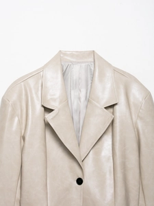Nahaufnahme des cremefarbenen PU-Lederblazers mit Reverskragen und schwarzem Knopfdetail