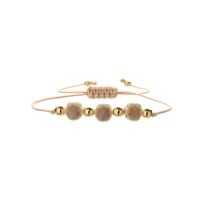 Handmade woven bracelet with ceramic flower charms and golden beads on white background