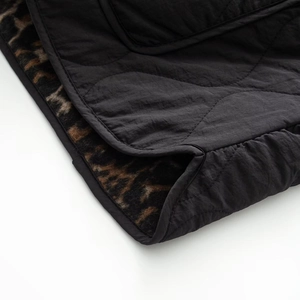 Detail showing the wavy quilting pattern and leopard print lining on this black vest