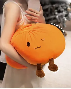 Close-up of soft plush orange cartoon pillow showing embroidered cute expression and soft fabric