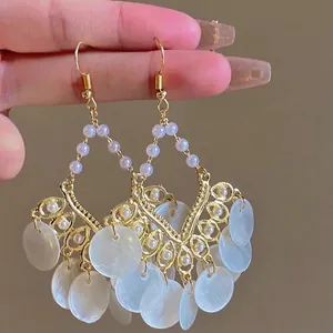 Details von böhmischen Goldohrringen mit weißen Perlen und schillernden Muschelscheiben