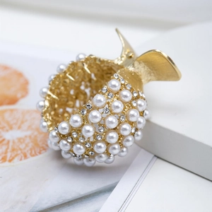 Macro shot of gold metal hair claw clip with inlaid white pearls and clear rhinestones