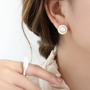 French vintage gold earrings with white pearls shown on a model with a matching ring