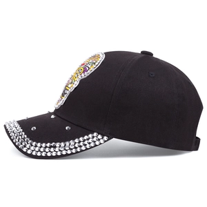 Black baseball cap featuring skull patch and four rows of rhinestones on the brim