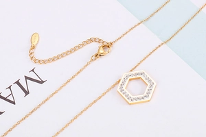Detail of gold hexagon necklace with crystals and stainless steel clasp mechanism