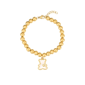 Detailed macro view of golden beaded bracelet featuring a white bear charm and heart detail