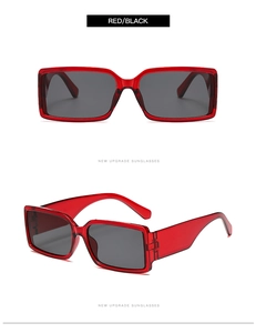 Detail view of red rectangular sunglasses with thick temples and dark lenses