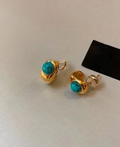Macro shot of 18k gold plated turquoise stud earrings with polished blue mineral stones