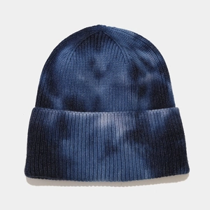 Detail view of the soft tie-dye blue knit texture and rolled cuff on this winter beanie