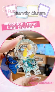 Close-up of a creative astronaut keychain with blue planet charm and colorful liquid quicksand