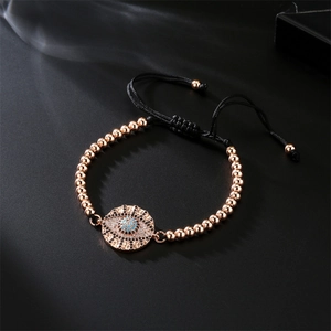 Detailed macro view of evil eye bracelet with rose gold beads and adjustable cord