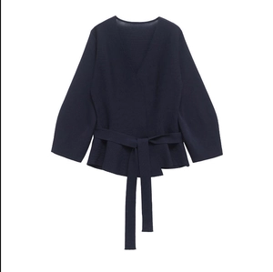 Detail of dark blue wrap knit sweater with waist tie and ruffled hem design