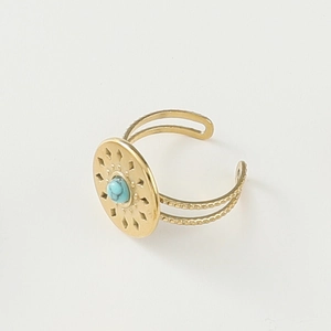 Detail of bohemian gold ring showing a turquoise center stone and sunburst pattern