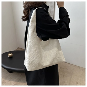 Dettaglio della trama intrecciata bianca e grande capacità della borsa shopper in ecopelle