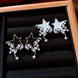 Detailed view of star-shaped earrings with mother of pearl and black zircon in a velvet box
