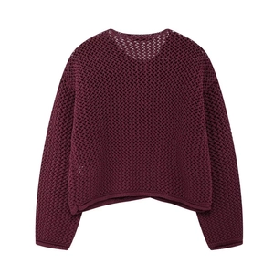Vue détaillée de la maille bordeaux épaisse et du crochet ajouré sur le pull à manches