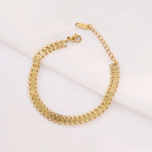 Detailed close-up of a gold-plated stainless steel mesh bracelet with adjustable lobster clasp