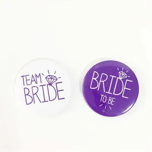 Detail of purple and white tinplate badges with Team Bride and Bride to Be text