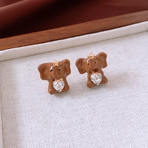 Detailed view of cute brown elephant stud earrings with heart crystal and gold star