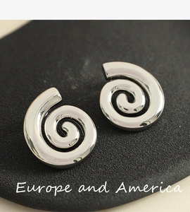 Détail macro de boucles d'oreilles spirales argentées avec surface métallique polie en 3D