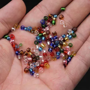 Macro shot of 2-4mm colorful glass seed beads for DIY jewelry making on open hand