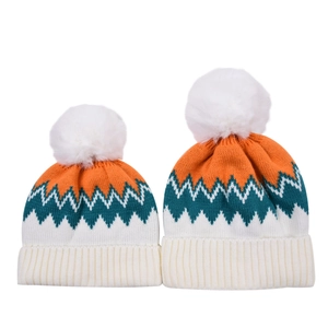 Detail of color-block knit beanies with zigzag patterns and detachable white pom poms