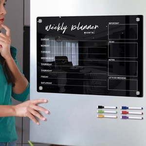 Magnetic black acrylic weekly calendar on fridge with six colored markers and plan sections