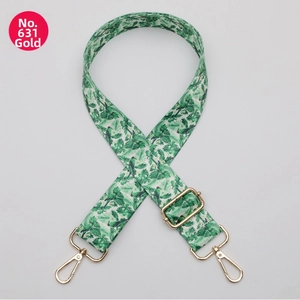 Detail of green floral and bird pattern bag strap with gold metal swivel snap hooks