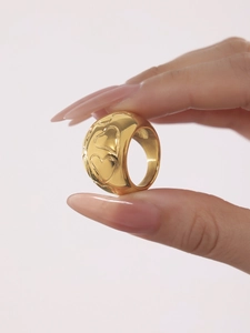 Close-up of 18k gold plated stainless steel ring with embossed heart pattern on hand