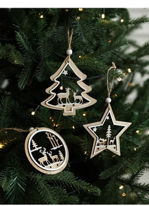 Detail of wooden Christmas ornaments with reindeer laser cutouts on a festive tree