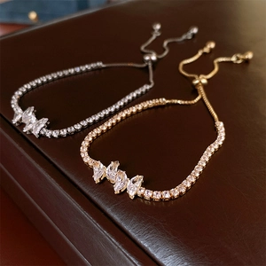 Adjustable zircon butterfly bracelet in gold and silver finish on leather background