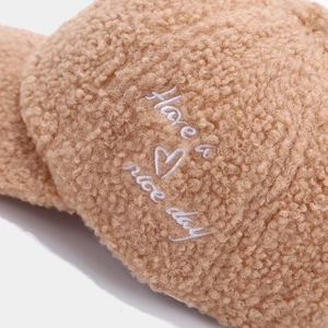 Macro detail of brown sherpa fabric with white Have a nice day heart embroidery