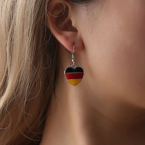 Minimalistische hartvormige oorbellen met Duitse vlagkleuren op een damesmodel
