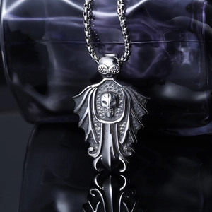 Gothic punk silver stainless steel bat wing skull pendant necklace on a dark reflective surface