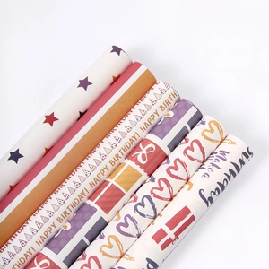 Colorful gift wrapping paper rolls with star, heart, and Happy Birthday patterns