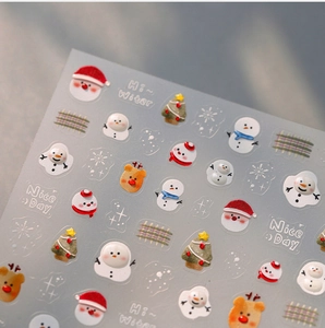 Makrofoto von 3D-Weihnachts-Nagelstickern mit Weihnachtsmann-, Rentier- und Schneemann-Motiven