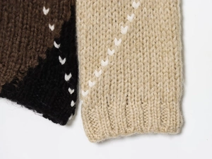 Detailed macro view of checkered knit fabric with decorative stitching and vibrant texture