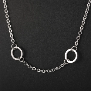 Detail of silver titanium steel necklace with interlocking double rings on black leather