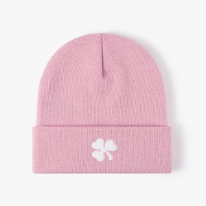 Pink knitted beanie with white clover embroidery for warmth in casual winter style