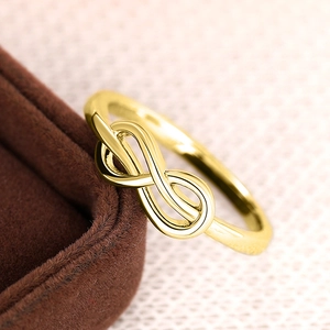 Macro-opname van een gouden infinity-ring op de rand van een bruine fluwelen sieradendoos