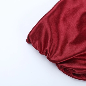 Detailed view of the dark red satin evening gown showing refined ruching and pleated edges
