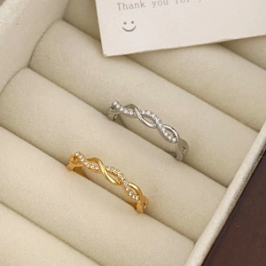 Macro shot of gold and silver twisted rings with micro-pave cubic zirconia inlay