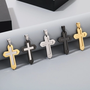 Détail de cinq pendentifs croix en acier inoxydable en finitions or, argent et noir